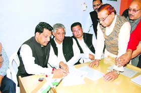 Gobind Kanda (left) fills his Congress membership form in Sirsa on Thursday as DCC chief Hoshiari Lal Sharma looks on