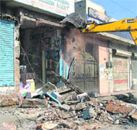 A portion of a shop being demolished in Ludhiana on Thursday.
