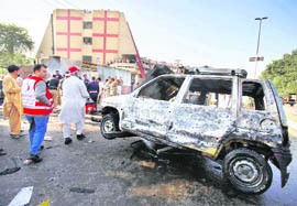 A damaged vehicle is removed from the blast site in Peshawar on Thursday.