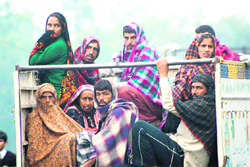 With the winter tightening its grip, these milk sellers try to keep themselves warm with blankets travelling in a vehicle in Jammu.