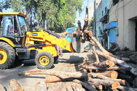 Illegal encroachments being removed by MC staff in Ludhiana on Friday. 