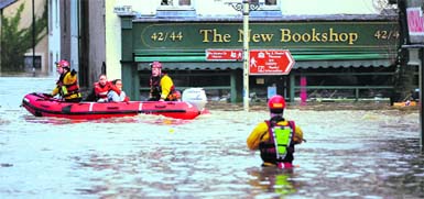  Emergency rescue workers use an inflatable boat to rescue flood-stranded residents of Cockermouth in northern England on Friday