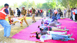 A mock drill being conducted by personnel of the EMRI, police and fire brigade at Parade Ground in Dehradun on Friday.