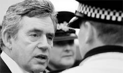 Britains Prime Minister Gordon Brown speaks to a policeman in Cockermouth, northern England, on Saturday