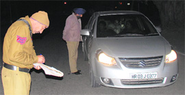 Police officials check documents of a car in the wake of growing incidents of crime in Sector 22, Chandigarh.