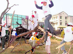 Children use a fallen tree at Rangers' College Ground to play in Dehradun on Sunday.