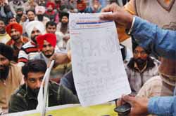 ETT teachers show a letter of shame during the gherao of Local Bodies Minister Manoranjan Kalias residence in Jalandhar on Sunday