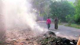 A morning walker covers his nose as smoke engulfs Rakh Bagh area in Ludhiana on Saturday.