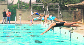 Girl swimmers dive in cold water 