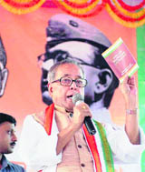 Finance Minister Pranab Mukherjee displays a booklet during the inauguration of a teaching centre at Raghunathganj in Murshidabad district of West Bengal on Sunday.