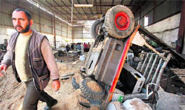 A Palestinian man inspects a metal foundry destroyed after an Israeli air strike in Jabalya, in the northern Gaza Strip, on Sunday