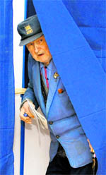 An elderly Romanian exits a voting booth at a polling station in Bucharest on Sunday