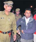 Anil Kumar, cashier of the electricity department, with police officials following a robbery in Industrial Area, Panchkula, on Monday.