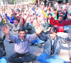 Employees of the Power Development Department protest in Jammu on Monday.