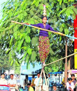 A girl does tight-rope walking on roadside in Haridwar on Tuesday.