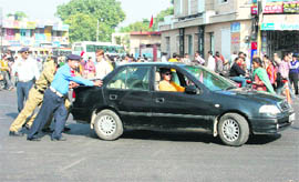 Traffic cops and NCC cadets help a vehicle get a start at Bikram Chowk in Jammu.