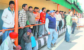 People wait outside the secretariat in Jammu.