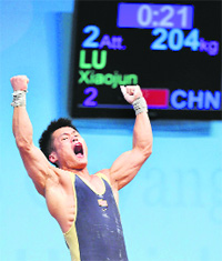 Gold medallist Lu Xiaojun of China reacts as he lifts 204kg in the mens 77kg Group A weightlifting clean & jerk competition at the World Weightlifting Championship in Goyang, north of Seoul, on Tuesday. Lu set new world records for the snatch (174kg) and total weight (378kg) lifted.