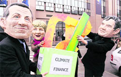 Protesters with face masks of German Chancellor Angela Merkel (centre), French President Nicolas Sarkozy (left) and British PM Gordon Brown take part in a protest on climate change ahead of the Copenhagen Climate Conference, in front of the European Council in Brussels