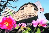 A pedestrian walks past the Bank of Japan (BOJ) headquarters in Tokyo