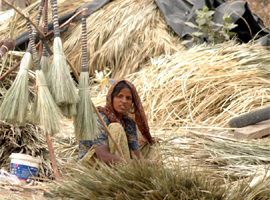 A woman makes broomsticks in Gurgaon