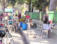 A dhaba on a pavement; the makeshift home of a beggar in front of the Doon Hospital