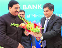 Chief Minister Ramesh Pokhriyal Nishank being welcomed at the inauguration of Yes Bank branch in Dehradun on Wednesday