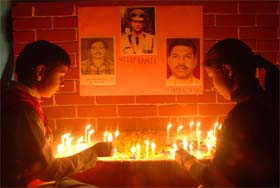 Children light candles to pay tributes to the martyrs of November 26 Mumbai terror attacks last year, in Bathinda