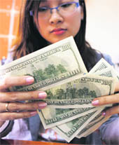 A bank staff checks US dollars at a bank in Hanoi on Wednesday. Vietnam announced on Wednesday it would devalue the dong by over 5 per cent, raise interest rates and request big exporters sell foreign exchange to the central bank in a dramatic bid to underpin the beleaguered dong currency.