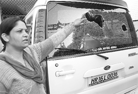 Kusum Sherwal, wife of INLD leader Ashok Sherwal, shows the broken windowpane of their vehicle in Sector 16, Panchkula, on Thursday.