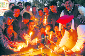 Congress workers light candles to pay tributes to Mumbai attack martyrs in Dehradun on Thursday.