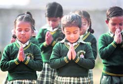 Students of National Public School hold a prayer in memory of martyrs of the Mumbai terror attack in Jammu on Thursday.