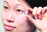 A model displays a 30.48 carat D-colour flawless oval diamond with an estimated value of $3.3 -3.8 million at Sotheby's autioneers in Hong Kong on Friday. The diamond is part of collection of jewels to be auctioned in New York on December 9. 