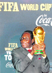 Zimbabwes President Robert Mugabe holds the FIFA soccer World Cup trophy at Harare International Airport on Wednesday. The trophy is on an 86 country 225 day world tour before it arrives in the host country South Africa for the 2010 tournament. 
