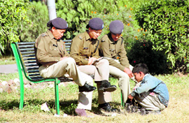 Policewomen get their shoes polished by a shoeshine boy at Gandhi Park in Dehradun.