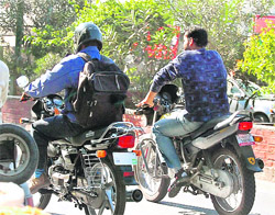 A motorcyclist (left) drives his vehicle without registration number in Dehradun. 