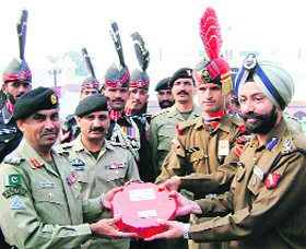 Pakistani Rangers led by Brigadier Kamran offer sweets to BSF authorities led by HS Dhillon, Commandant, to mark Id at the Attari-Wagah check-post on Saturday