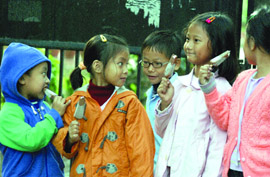 Children enjoy ice-creams on a chilly Sunday in New Delhi. 