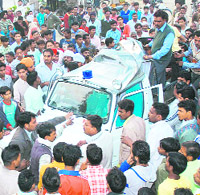 Residents try to stop a police car at Pal Nagar in Karnal on Sunday.