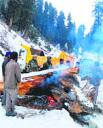 Residents warm themselves at Dubjan in South Kashmir on Sunday