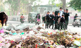 Schoolchildren walk past a garbage dump on 