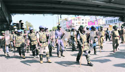 Riot police personnel stand guard during a protest by students at Osmania University in Hyderabad on Monday.