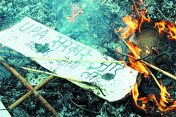 A banner lies in the ashes as activists (not seen) of the Bharatiya Yuva Morcha protest against the Centre over inflation and price rise in Amritsar