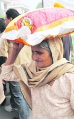 An old woman carries home a bag of fortified wheat flour distributed by the department of food and civil supplies in Ludhiana on Tuesday.