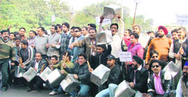 BJYM workers raise slogans against hike in prices of essential commodities in Ludhiana.