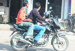 Motorcyclists without helmets ride through Dehradun with impunity.