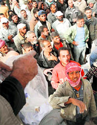 Palestinians wait to receive sacks of flour from the United Nations Relief and Works Agency headquarters in Rafah refugee camp in the southern Gaza strip on Wednesday