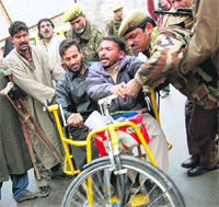 Policemen stop members of the All-Jammu and Kashmir Handicapped Association from holding a protest march in Srinagar