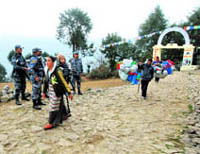 Nepalese women walk past security officials in Lukla village, where the Himalayan nation's government is holding a Cabinet meeting on Friday to draw the attention of the world to climate change in the Himalayas, on Thursday.
