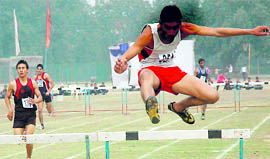 Participants take part in hurdles event during the Inter-College Athletics Meet at Panjab University, Chandigarh, on Friday.